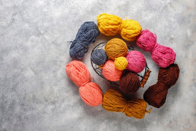 Balls of yarn in different colors with knitting needles.