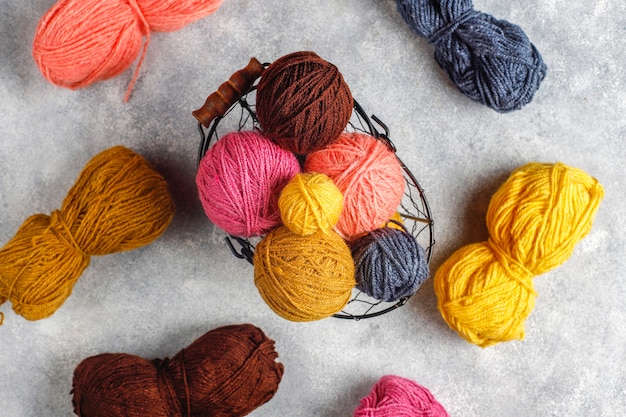 Balls of yarn in different colors with knitting needles.