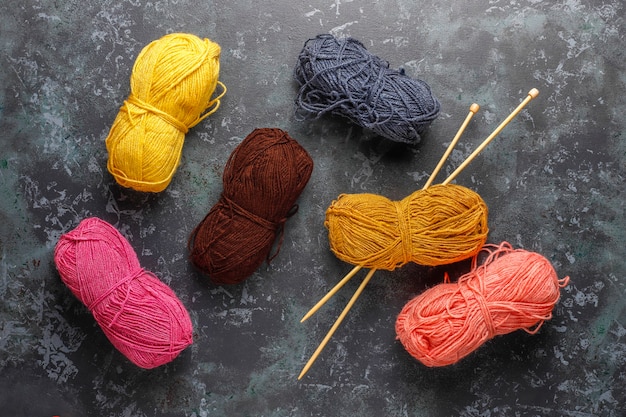 Balls of yarn in different colors with knitting needles.