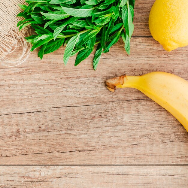 Banana, lemon and mint on table