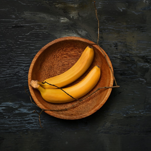 Free photo bananas on wooden bowl