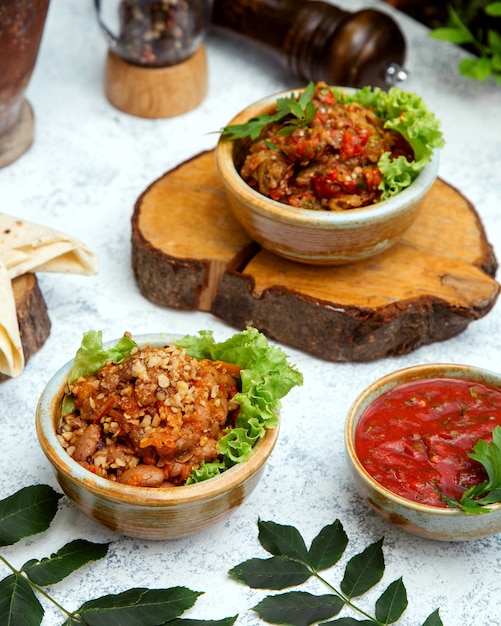 Barbecue salad in clay pot on a stump