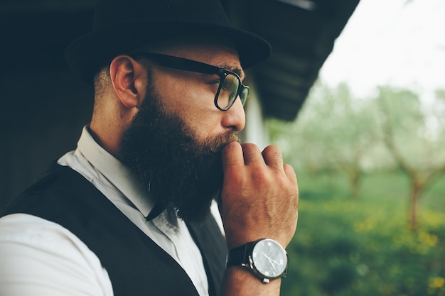 Free photo barber shaves a bearded man outdoors