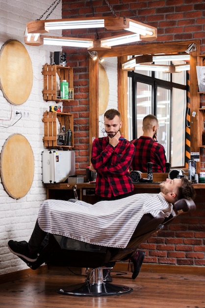 Free photo barber thinking of a hairstyle for customer