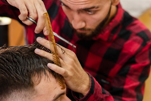 Barber using scissors and comb for hair