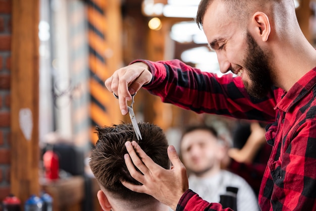 Free photo barber using scissors to make a hairstyle