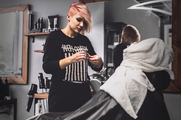 Barber woman and customer in towels