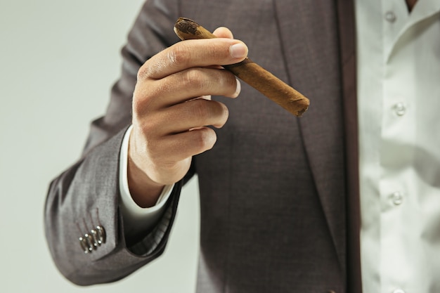 The barded man in a suit holding cigar