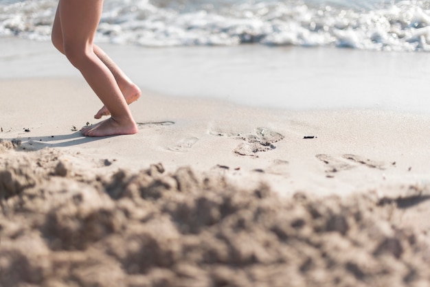 Free photo barefoot child playing by the seaside