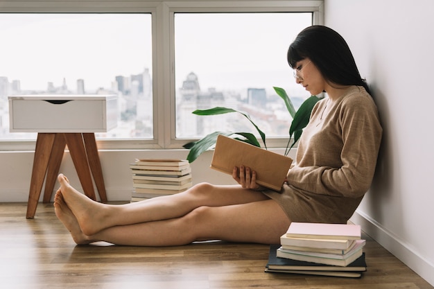 Barefoot female reading on floor