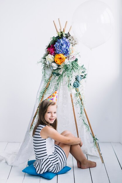 Barefoot girl with balloon near tent on birthday party