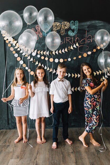 Barefoot kids with balloons on birthday party