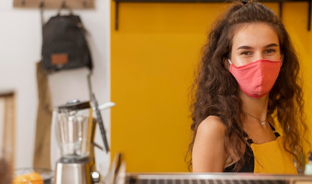 Free Photo barista wearing a face mask with copy space