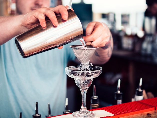 Free Photo barman filling cocktail glass with alcohol beverage