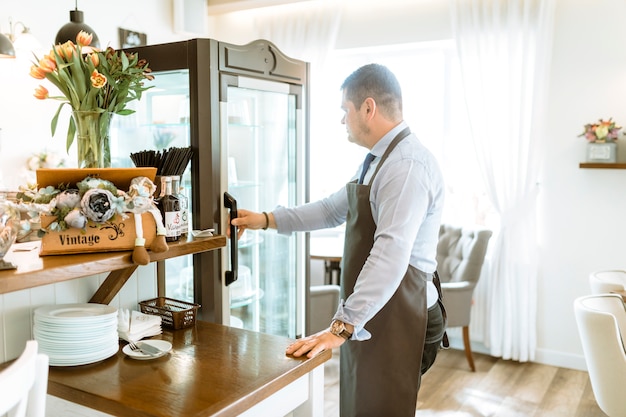 Free photo barman in front of fridge