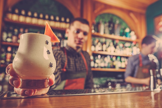 Free photo the barman offering an alcoholic cocktail at the bar counter on the bar space