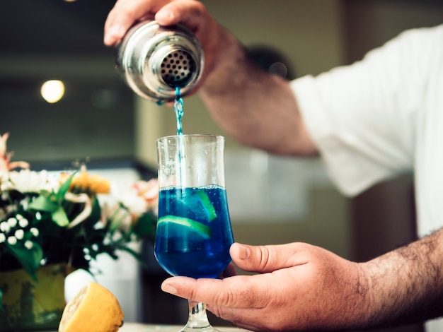 Free photo barman pouring alcoholic drink in cocktail