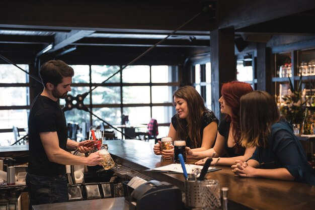 Bartender serving beer at bar counter