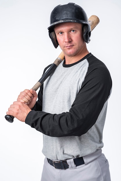 Baseball player posing with helmet and bat