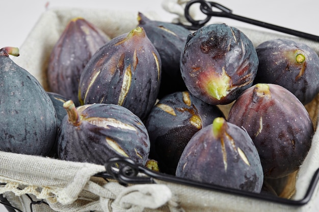 Free Photo a basket of purple figs on white.