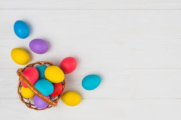 Free photo basket with easter eggs on table