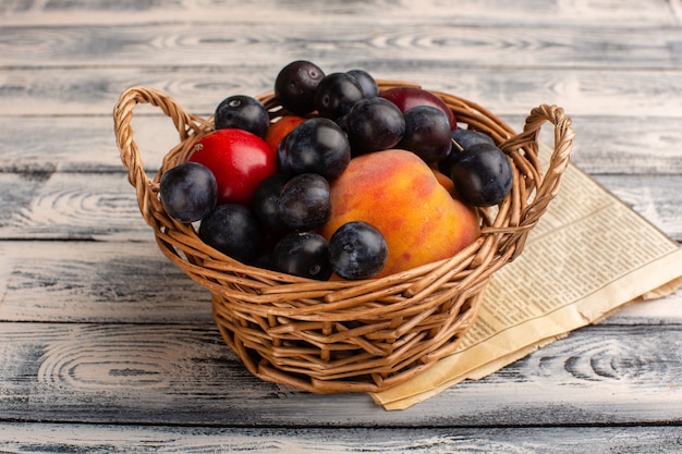 basket with fruits blackthorns peaches on grey wood