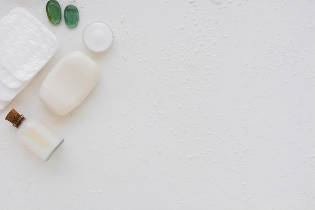 Bath products and cotton pads on white background with copy space