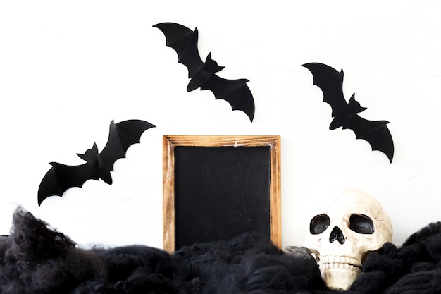 Free photo bats over skull and blackboard