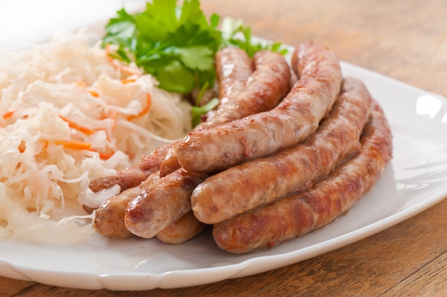 Free photo bavarian fried sausages on sauerkraut