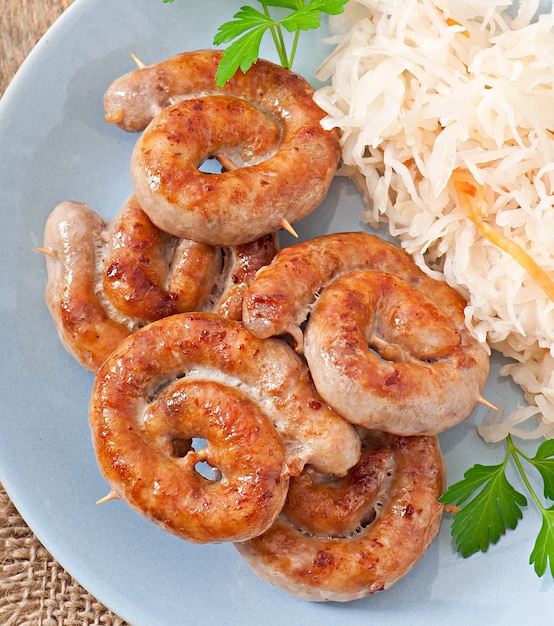 Free photo bavarian fried sausages on sauerkraut