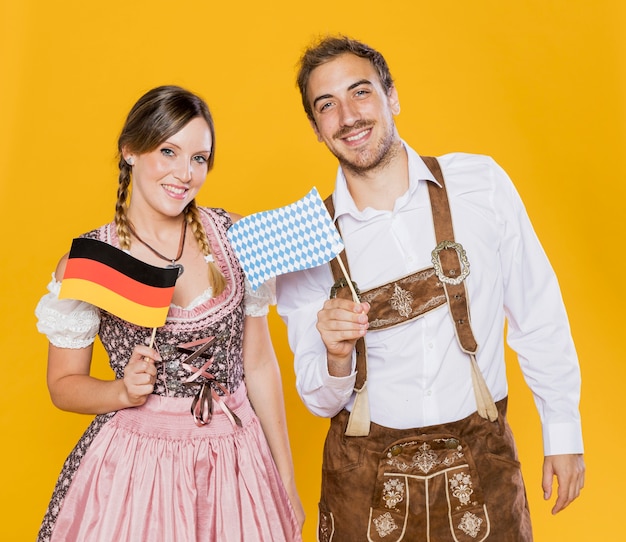 Free photo bavarian man and woman holding flags