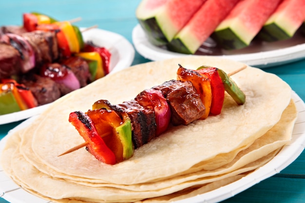 Bbq skewer with beef and vegetables on picnic table