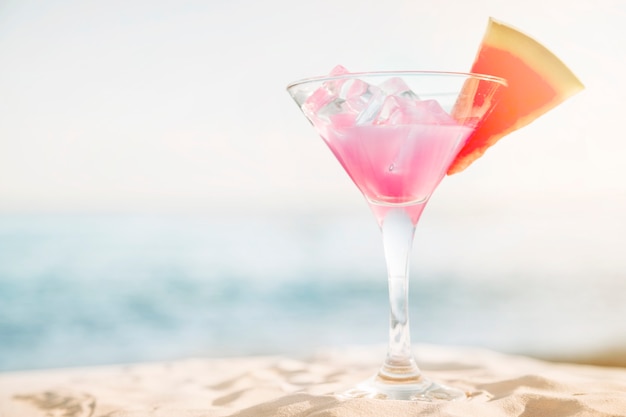 Beach background with pink cocktail and watermelon