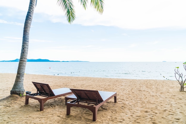 Free photo beach chair, palm and tropical beach at pattaya in thailand