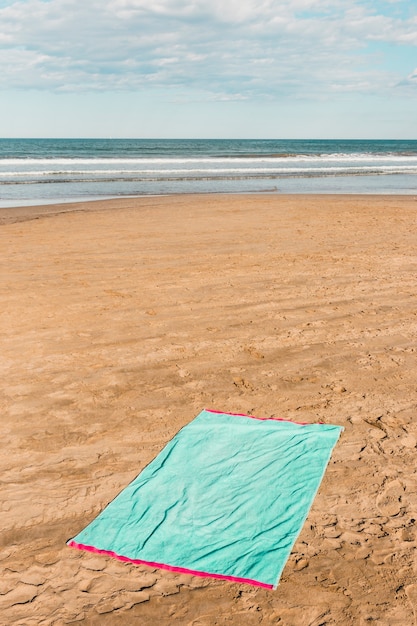 Beach concept with green towel