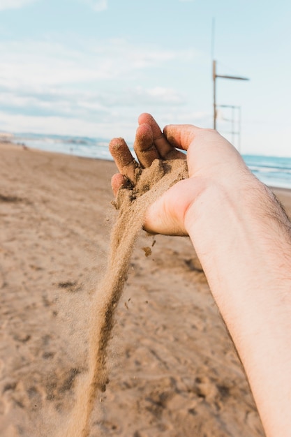 Beach concept with hand holding sand