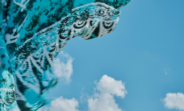 Beach scarf gracefully evolves against the sky Sea breeze on the coast closeup of a poreo blurry not sharp background