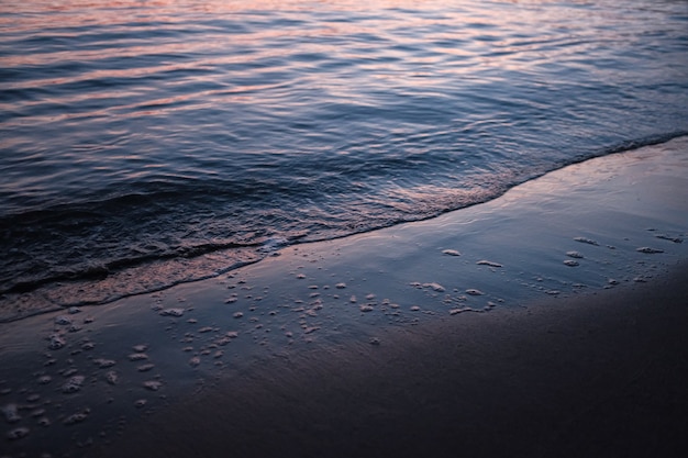 Beach surrounded by the sea under the sunlight during the sunset