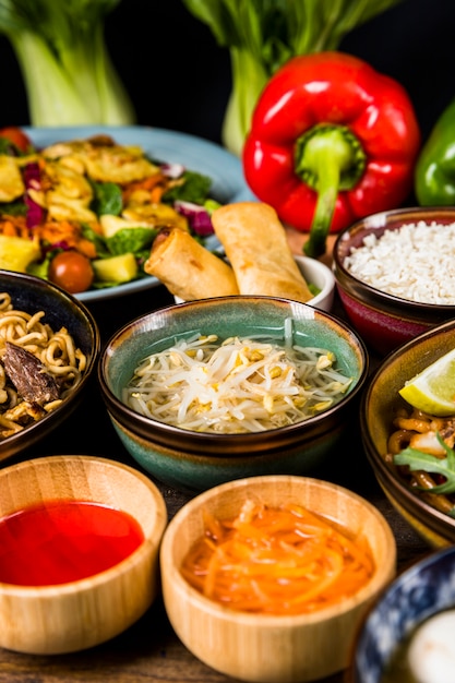 Free photo beans sprout surrounded with salad; sauce; spring rolls and noodles