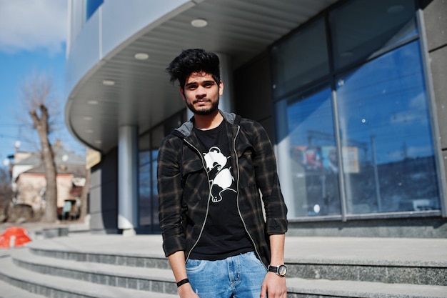 Free photo beard asian man in casual wear posing against new modern building