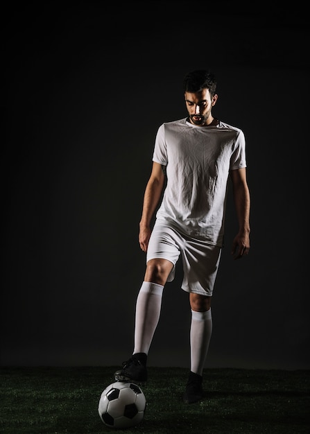 Bearded athlete stepping on ball