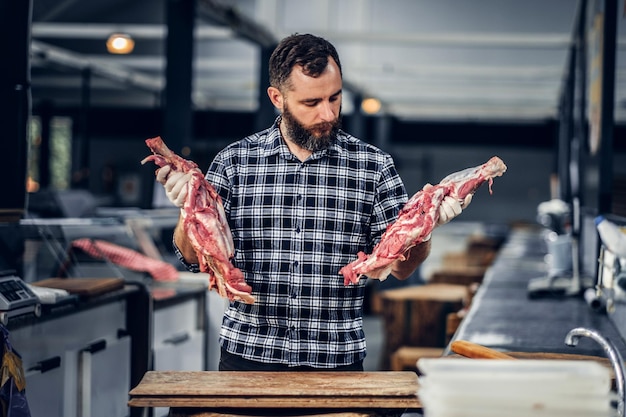 Free photo bearded butcher dressed in a fleece shirt working in butchers shop