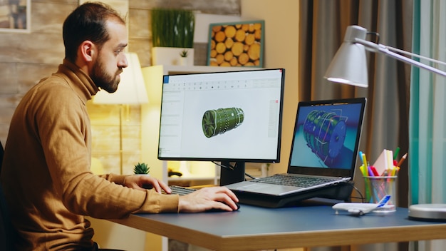 Free photo bearded engineer sitting at his desk in home office working on a turbine.