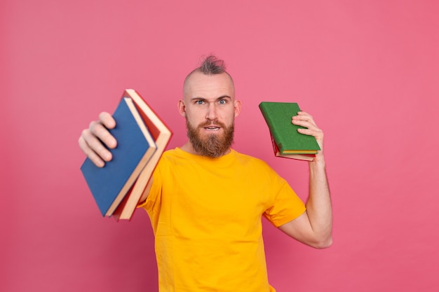 Free photo bearded european man with stack of books on pink