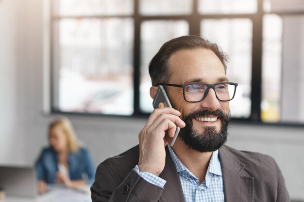 Bearded handsome male entrepreneur in formal clothes and eyewear