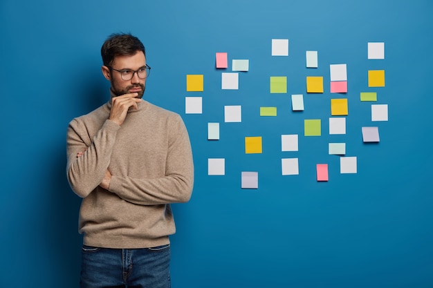 Free photo bearded male organizing his tasks using sticky notes