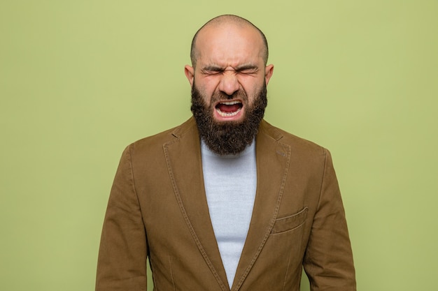 Free photo bearded man in brown suit shouting and yelling crazy mad and frustrated