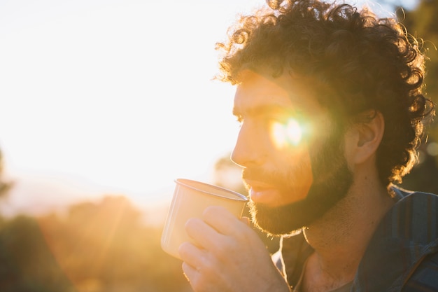 Bearded man drinking in nature