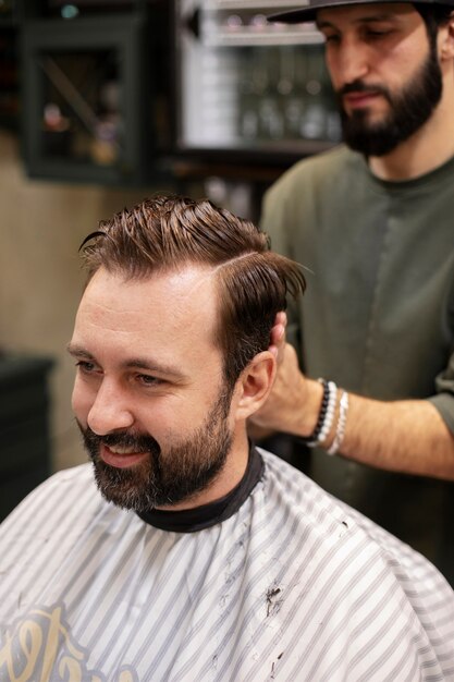 Bearded man getting his haircut at the barber's shop