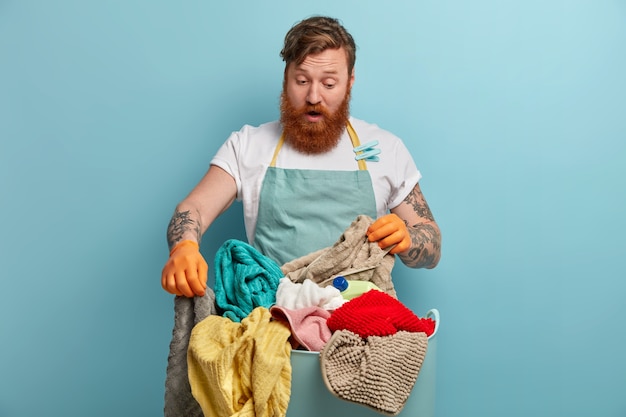 Free Photo bearded man holds laundry basket, overwhelmed by household chores